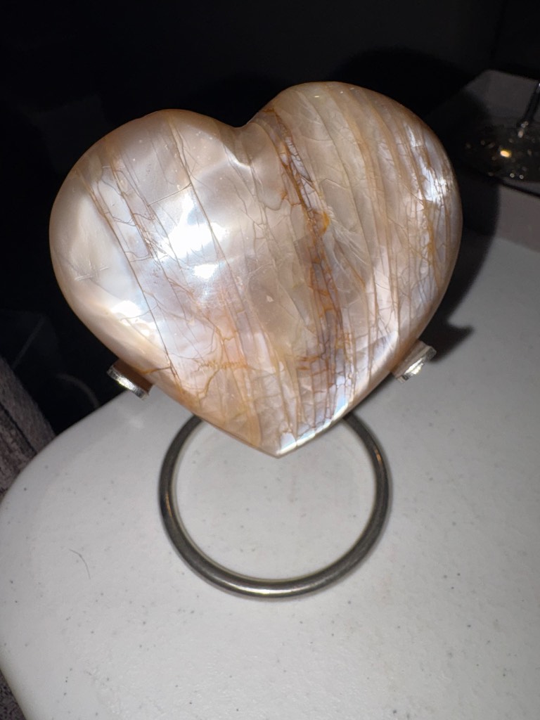 Flash peach moonstone heart on a silver stand