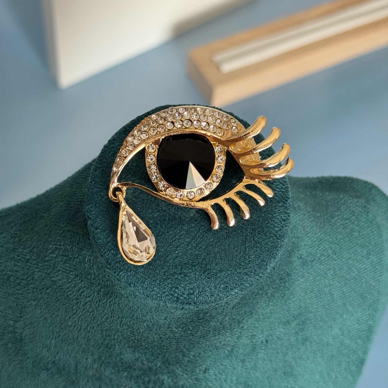 Black eye brooch with rhinestones and a tear drop