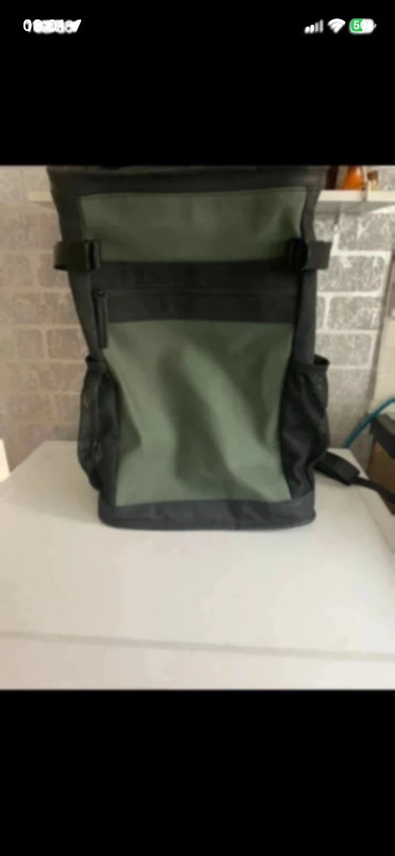 Primark green and black roll-top hiking and travel backpack.