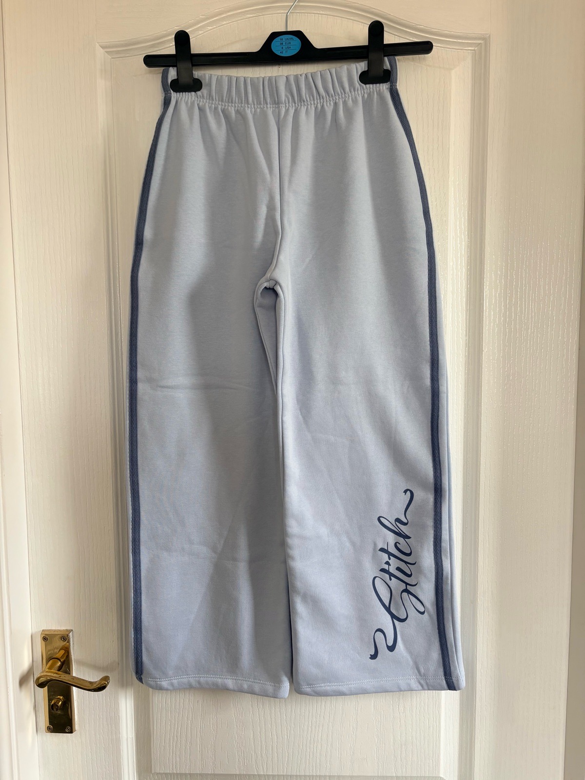 Disney’s Stitch girls pale blue, wide leg jogging bottoms. 8-9 years