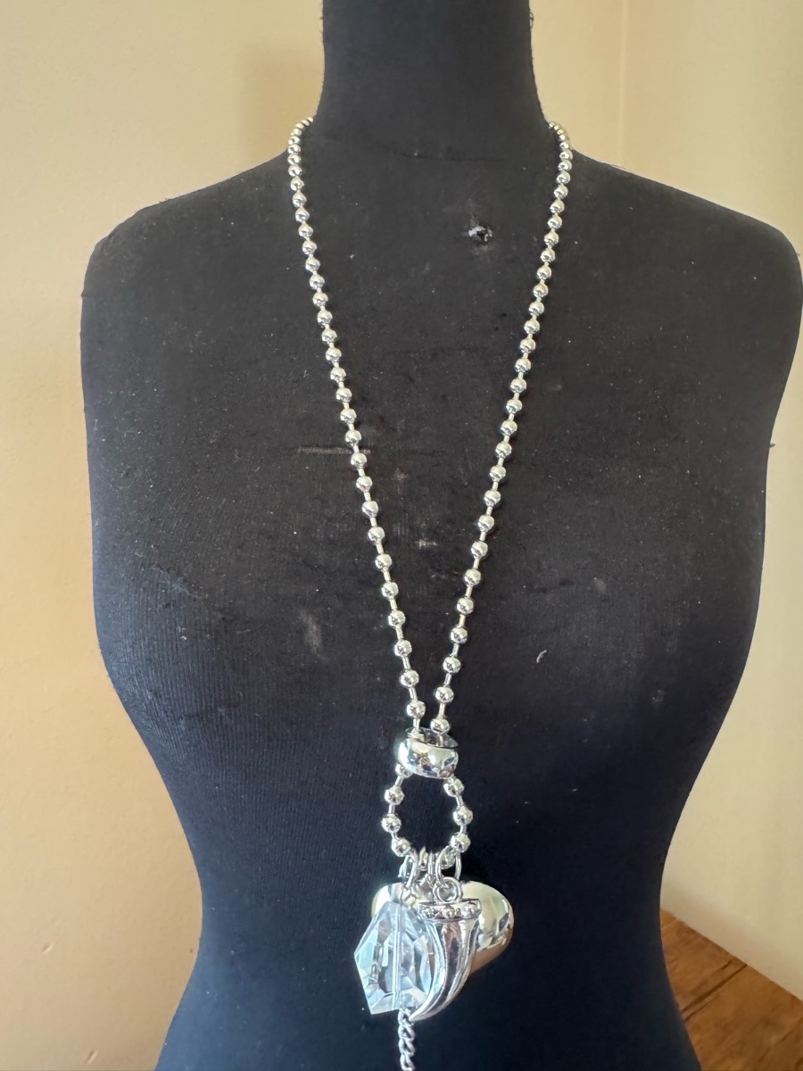 Long silver tone heart and charm necklace