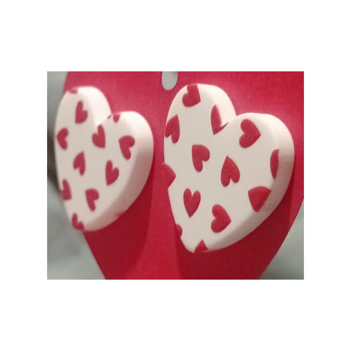 Ditsy style white resin heart shaped earrings with little red hearts. Studs.