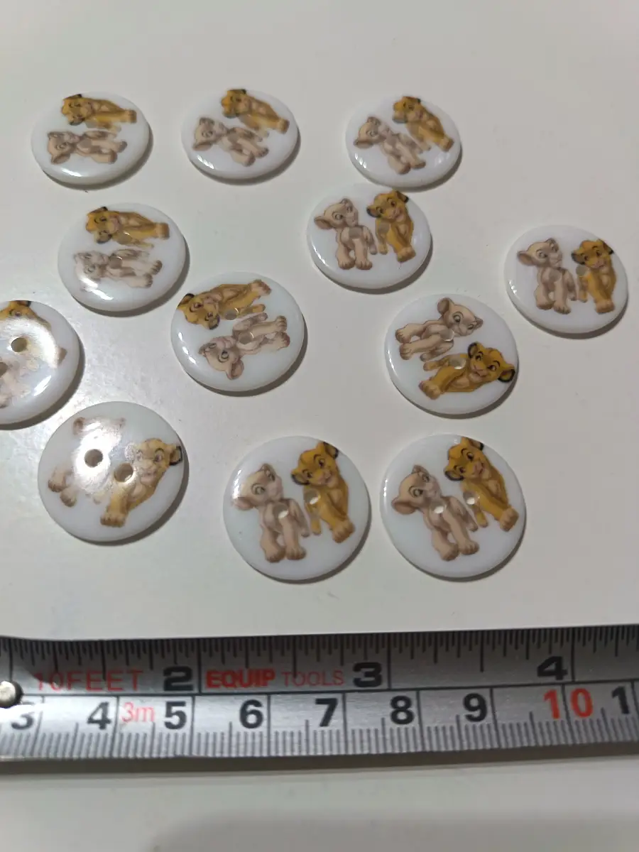 12 x round lion King sew through buttons white