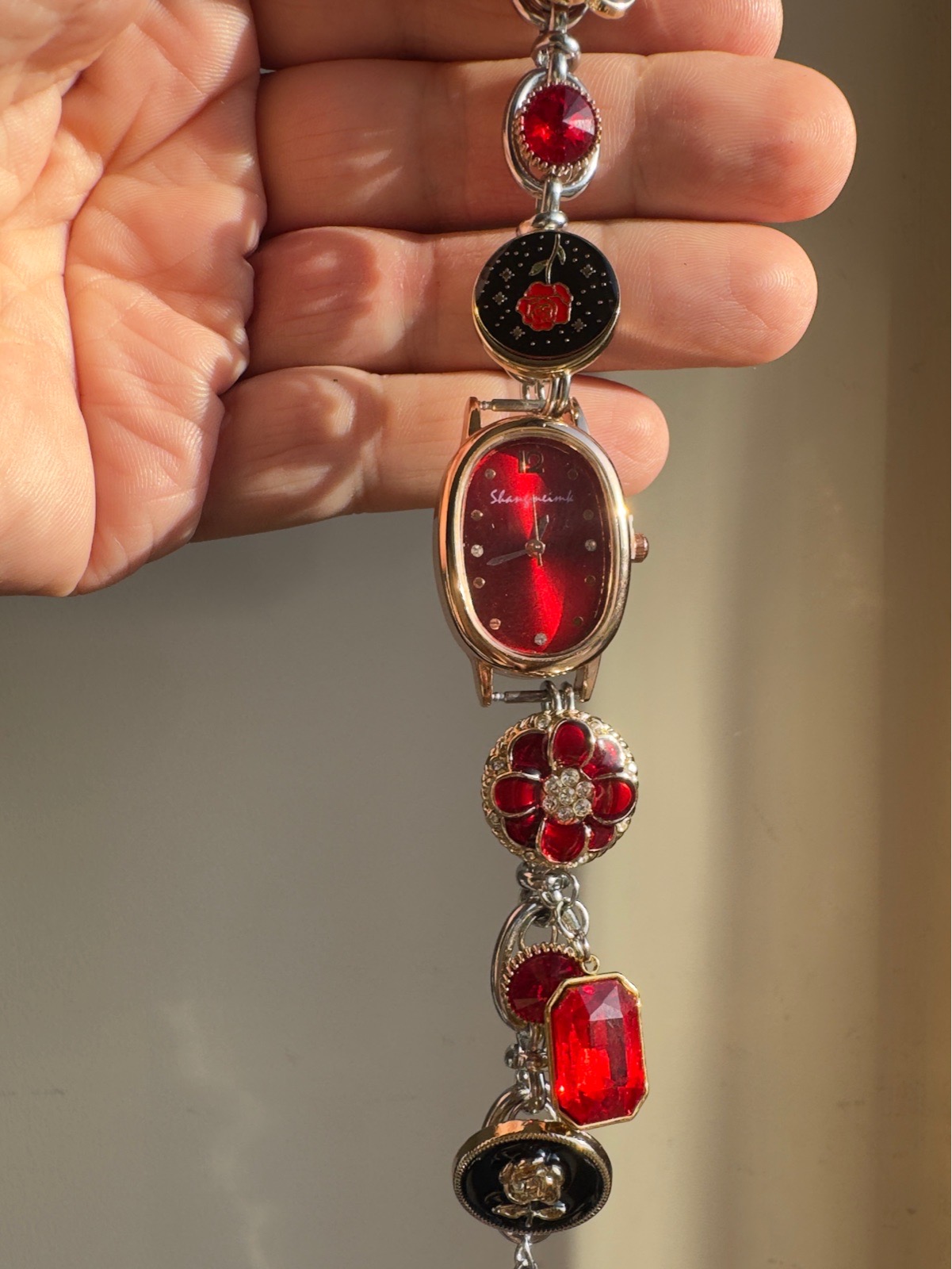 Stunning watch with multiple charms red tinted
