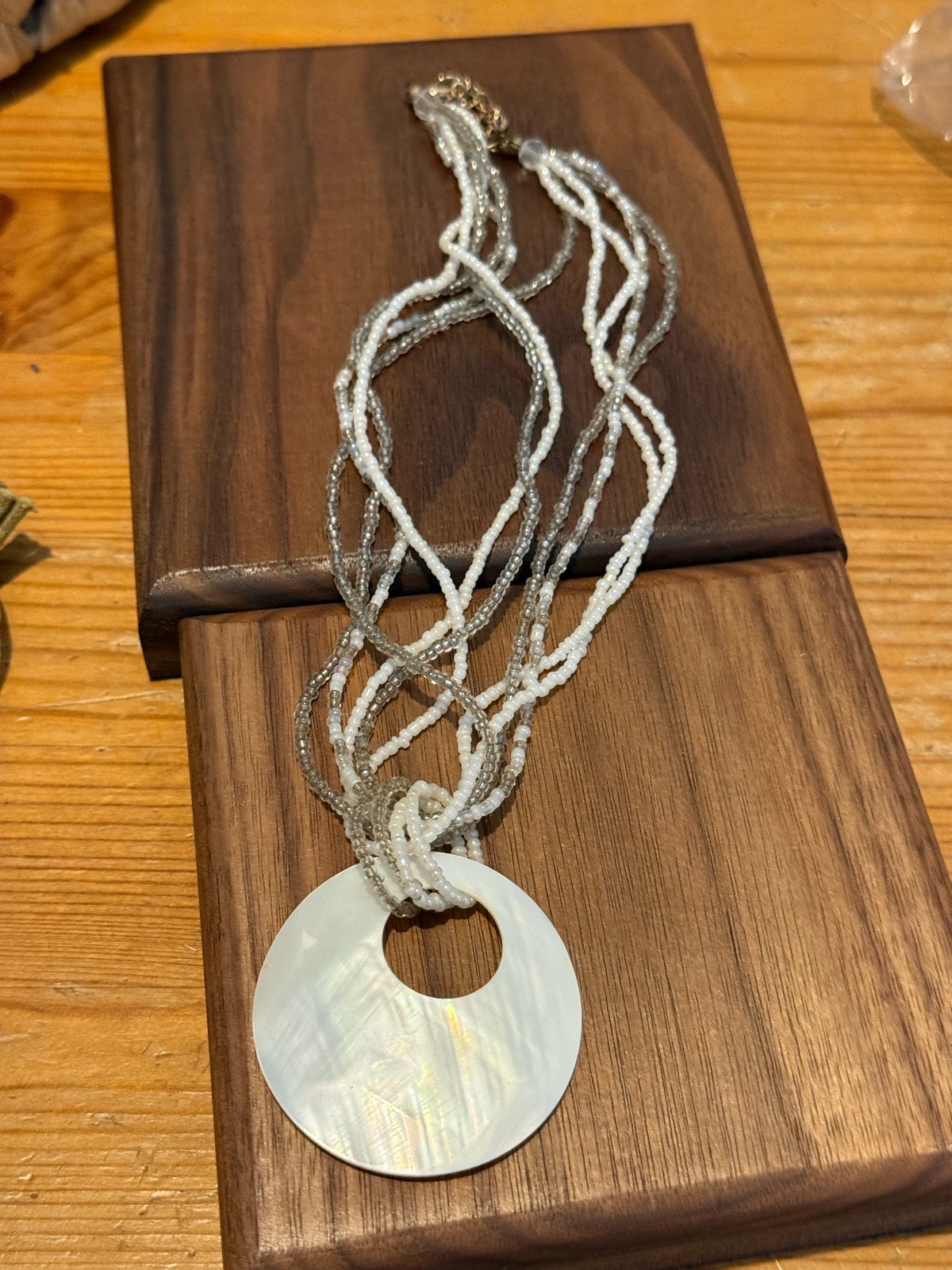 vintage style cream seed beaded necklace which wraps around a shell pendant