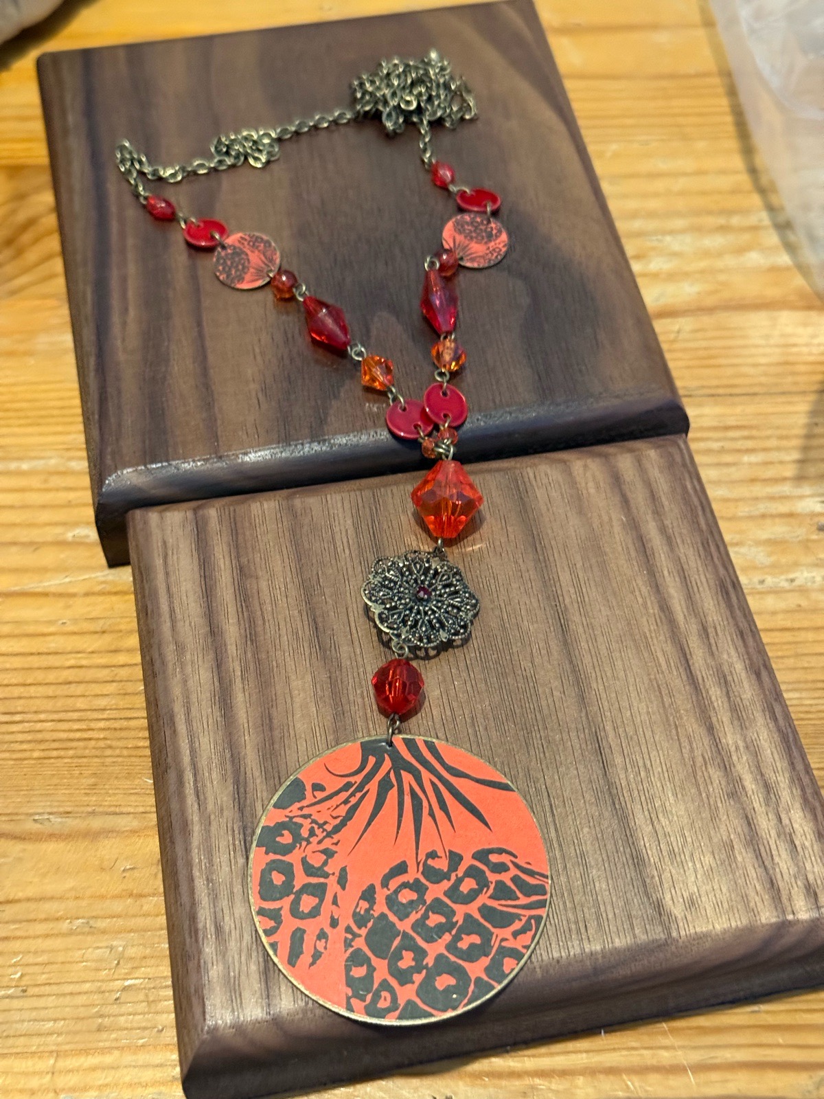 vintage beaded chain necklace with orange circular pendant with black leopard print and palm tree