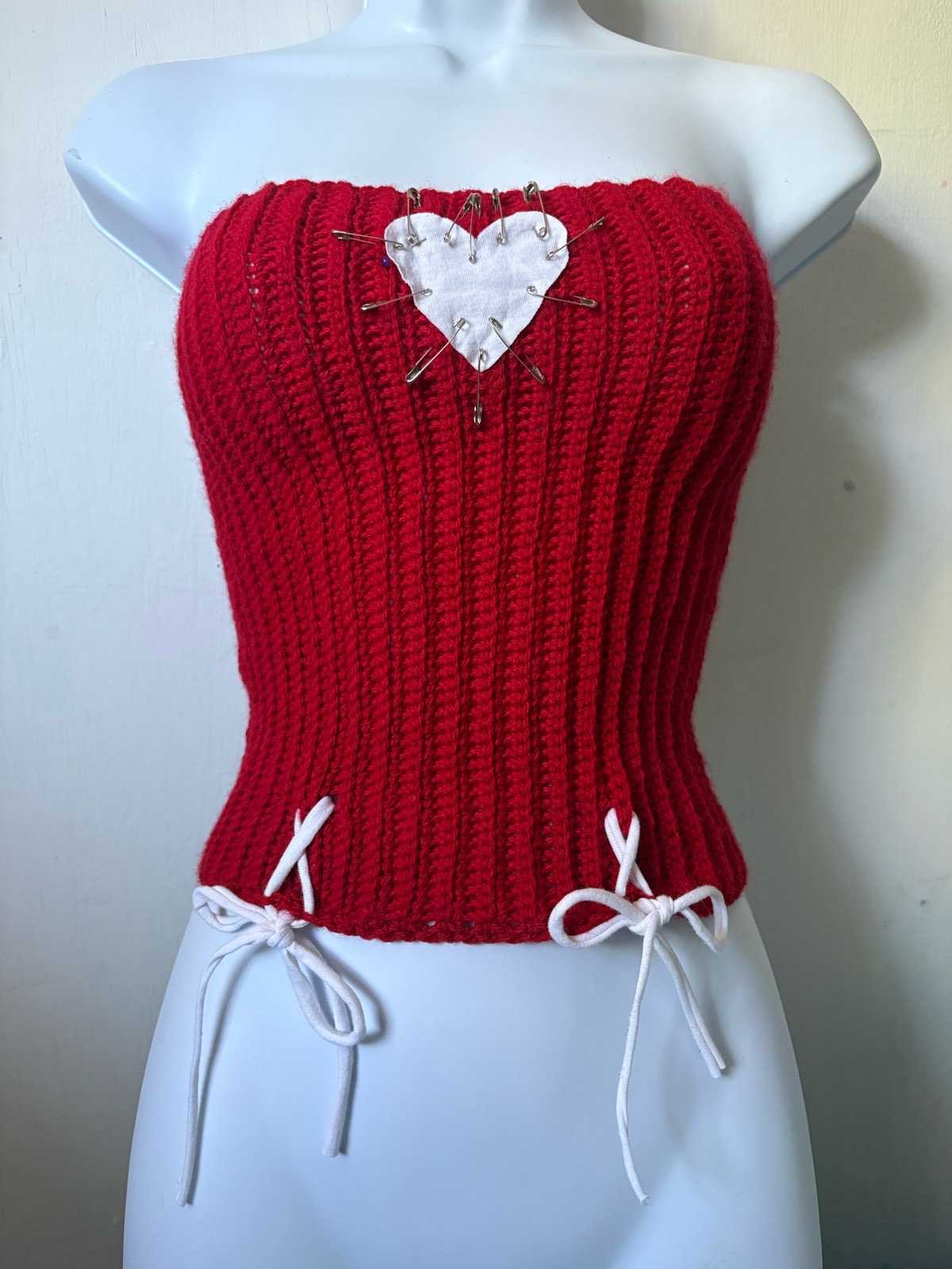 red crochet strapless of the shoulder crop top with ribbing for a corset look heart and safety pins