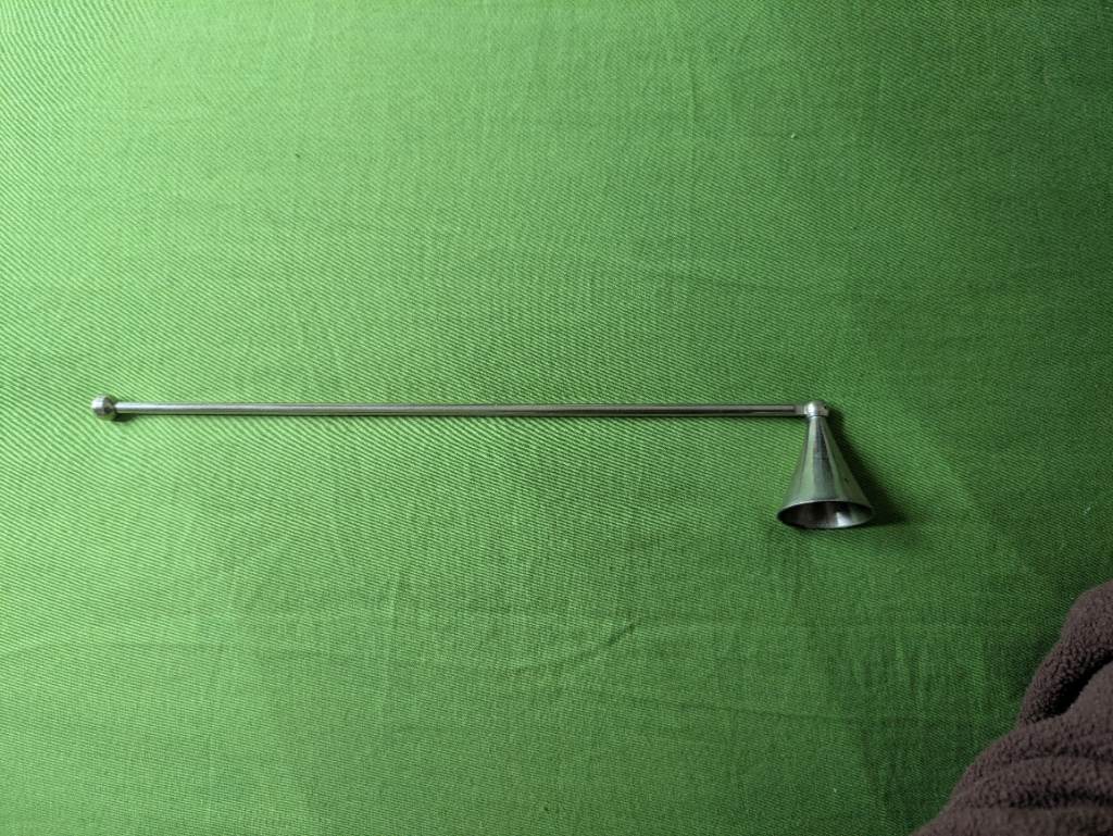 Long silver coloured metal candle snuffer with rotating head