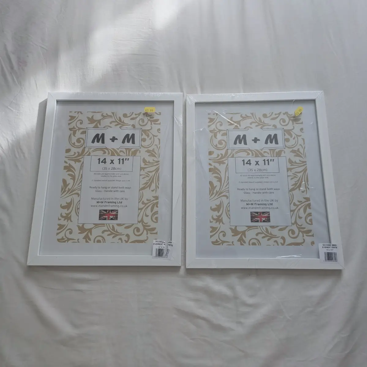 Two large 14" x 11" white wood and glass picture frames New