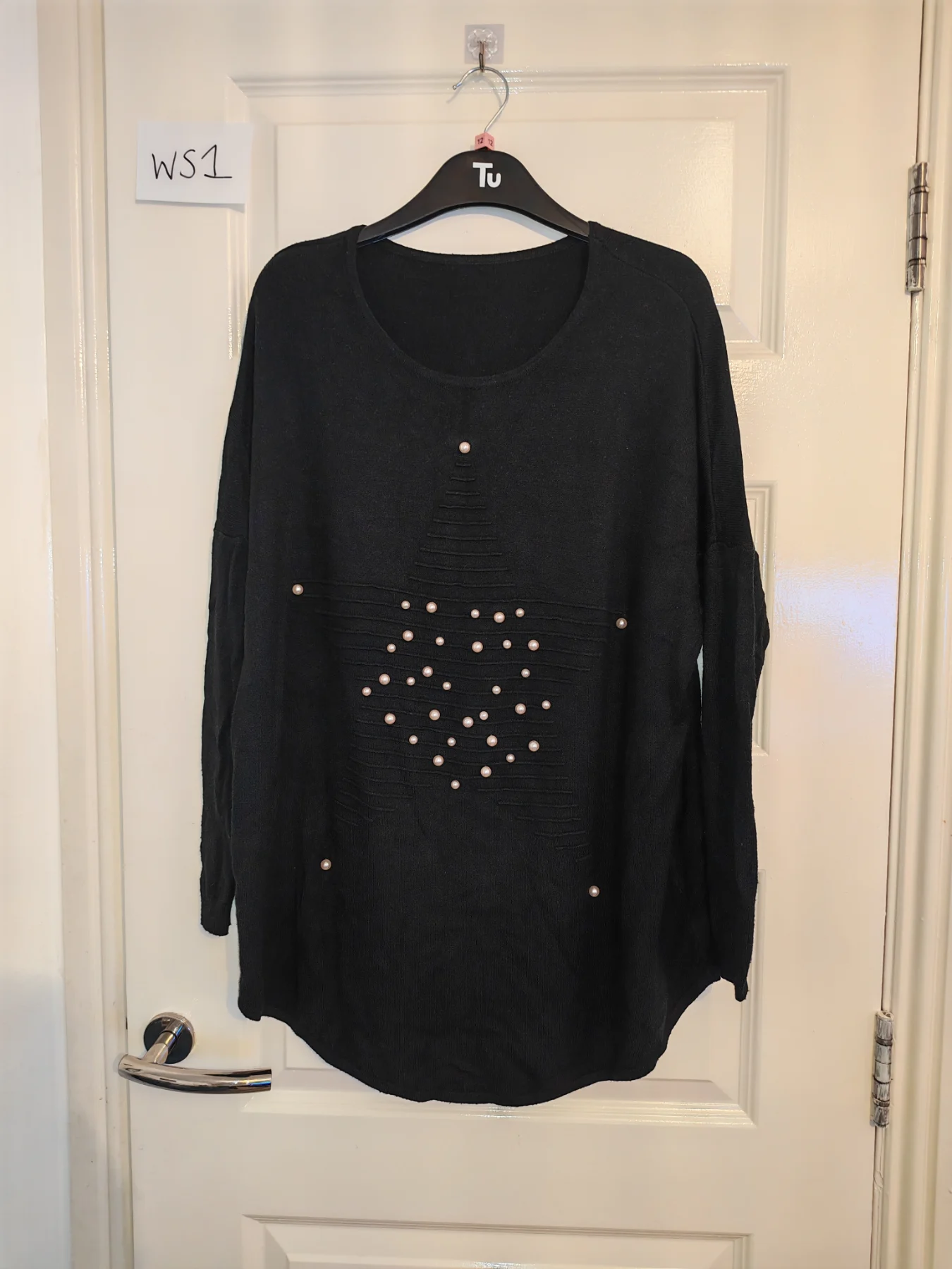 Woman's long sleeve black top with pearl detail on front
