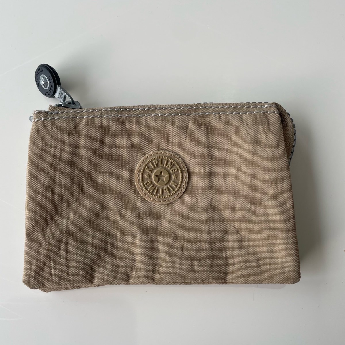 Kipling coin purse/ wallet in a khaki/ beige colour.