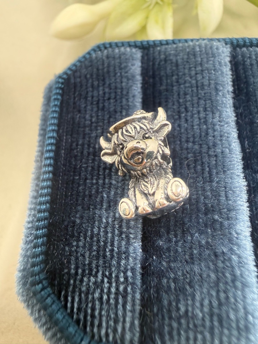 Sliver plated highland cow wearing a cowboy hat charm