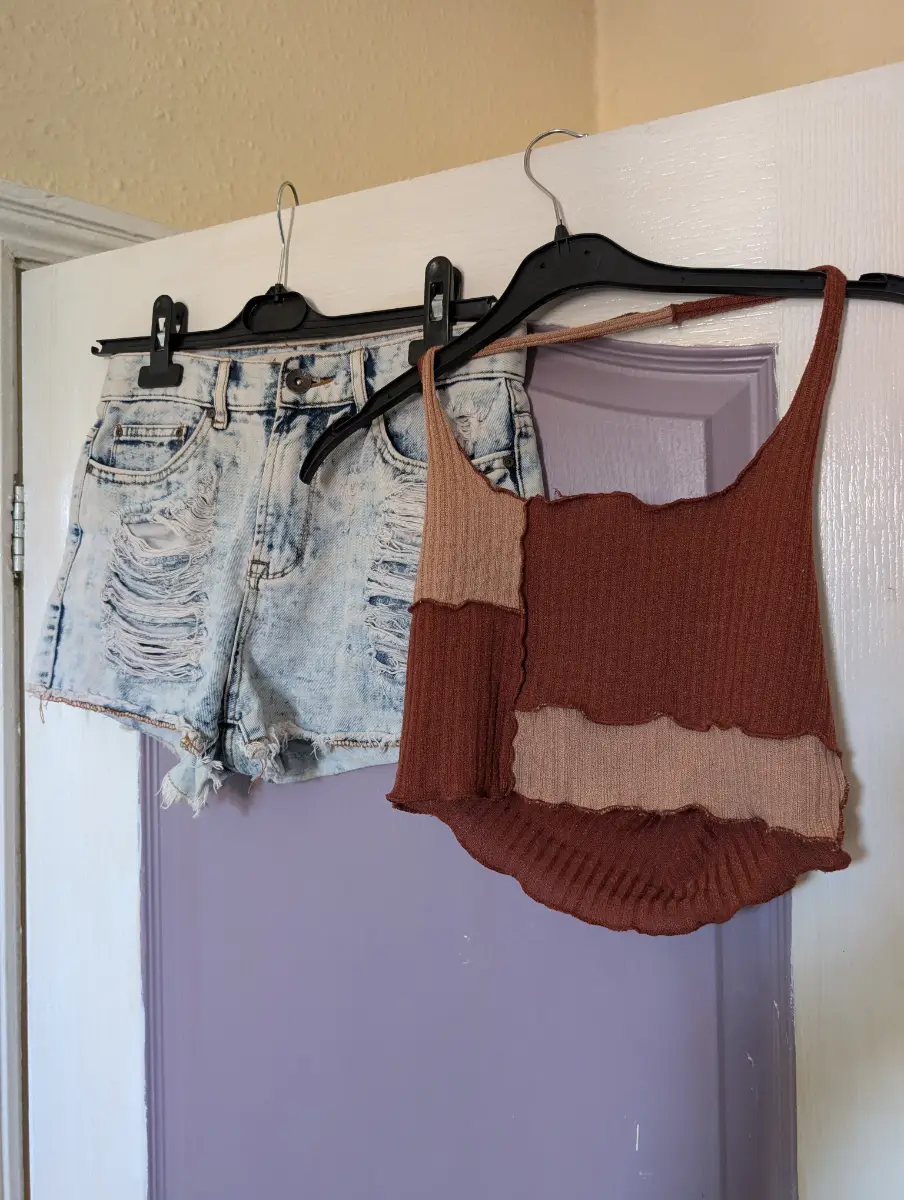 Light wash distressed denim shorts with a high-rise waist, Y2K style halter neck top