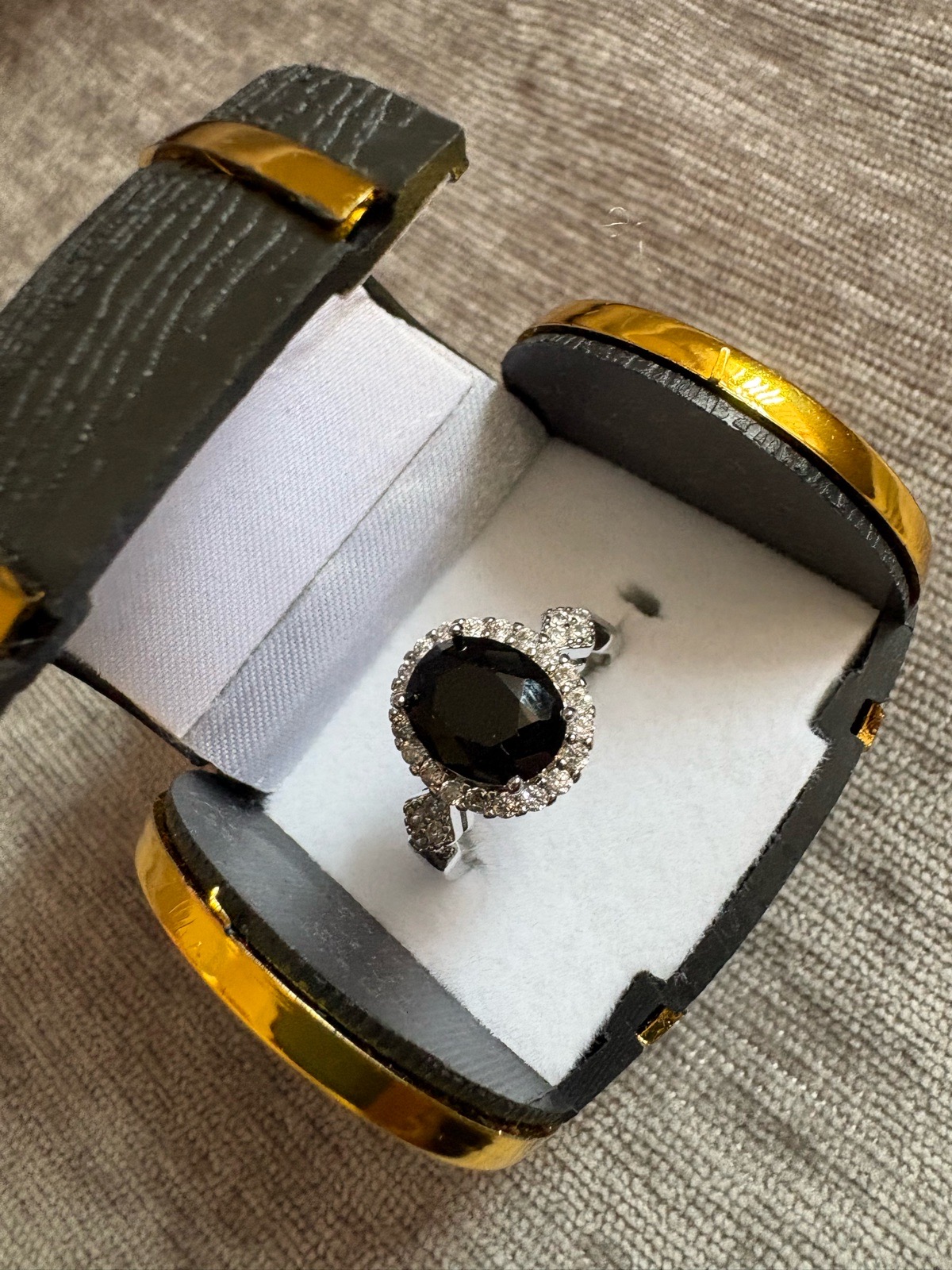 Silver ring with black stone in barrel ring box