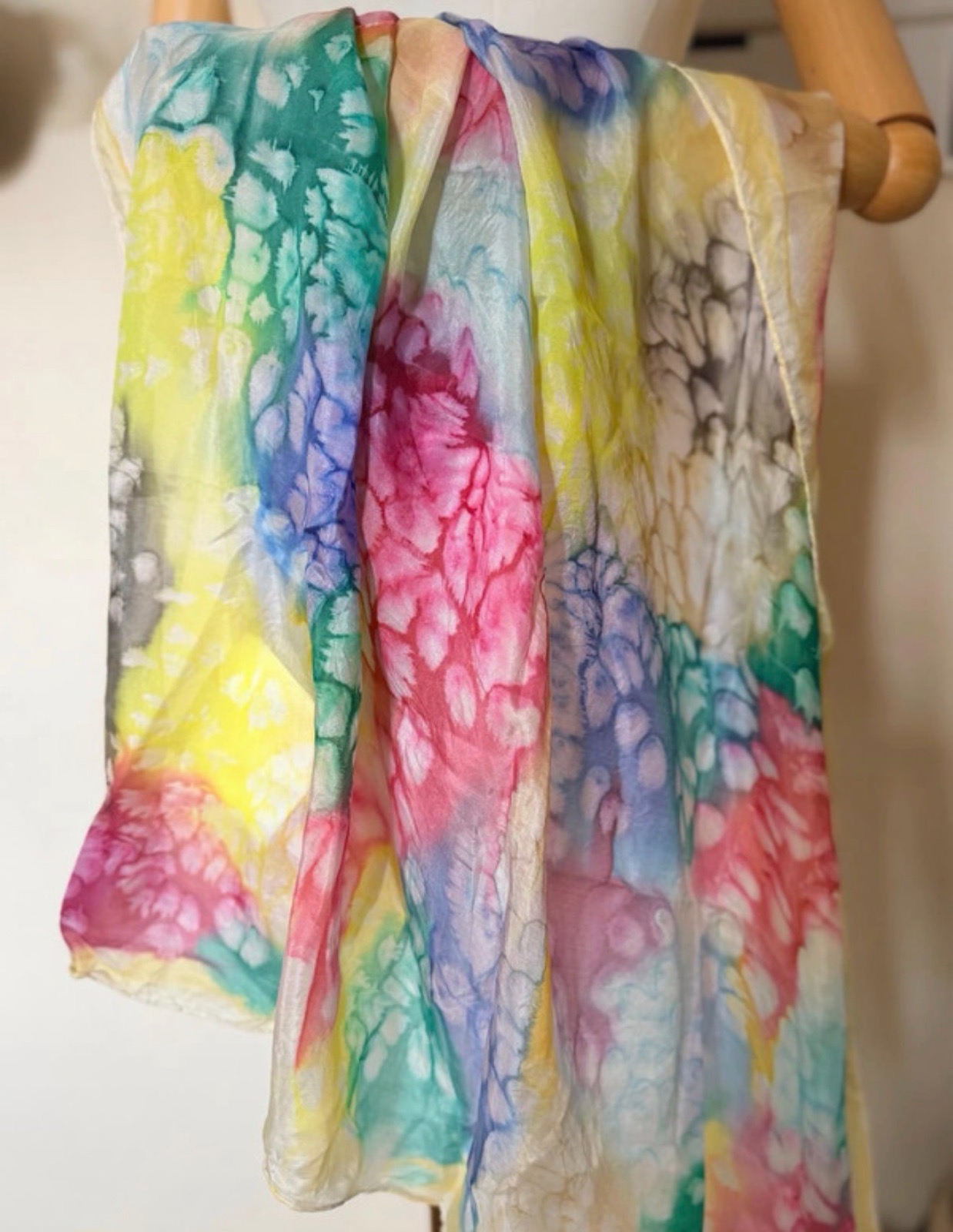 Multi-colored tie-dye scarf with floral-like splotches in pink, yellow, blue, and green