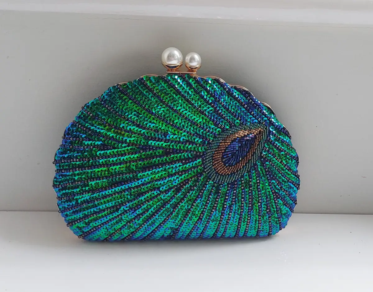 Peacock clutch bag with double pearl clasp.