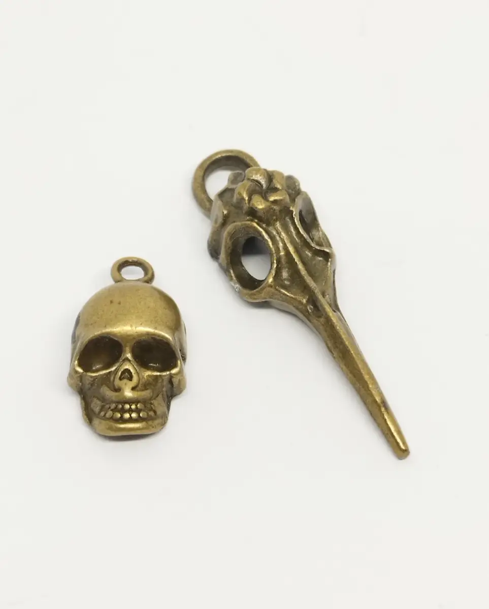 2 gold/brass tone skull pendants
