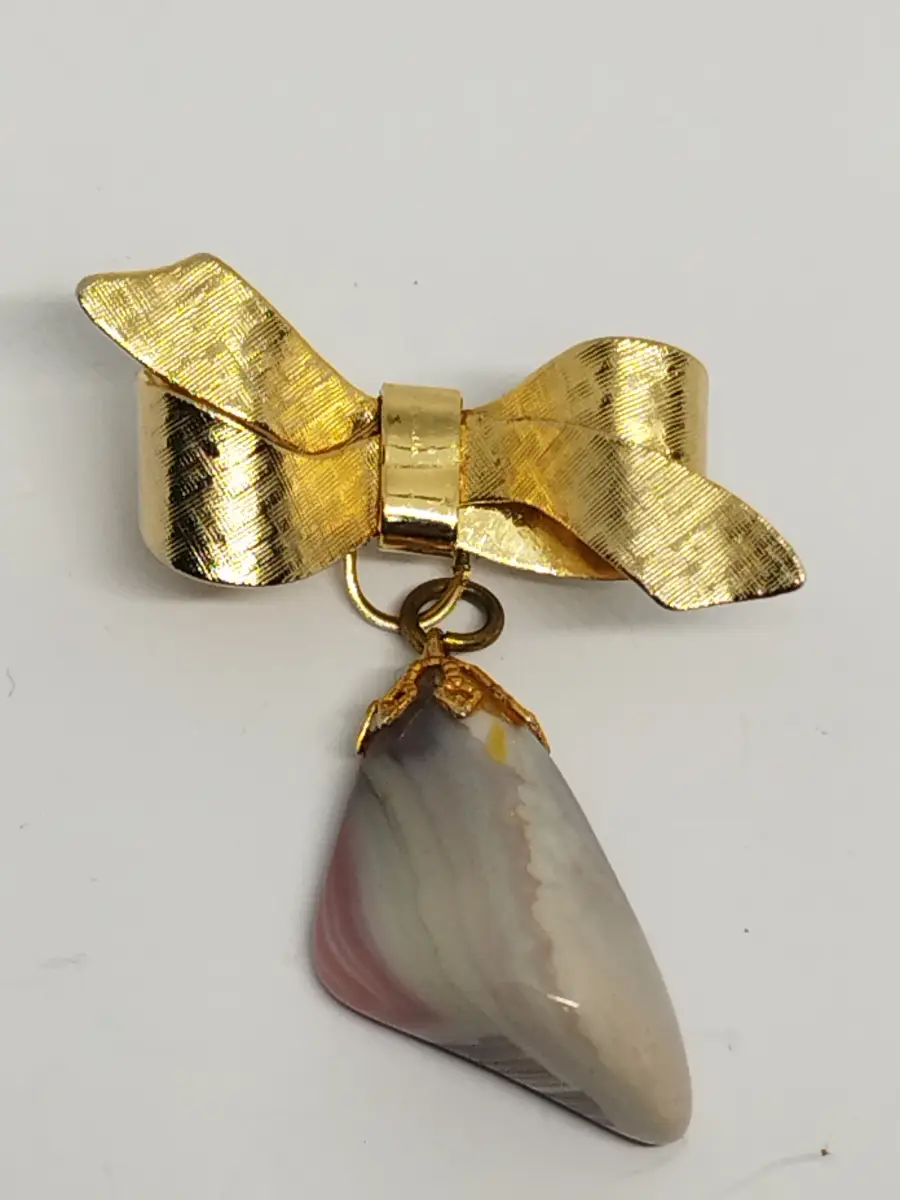 Gold tone bow brooch with hanging crystal stone