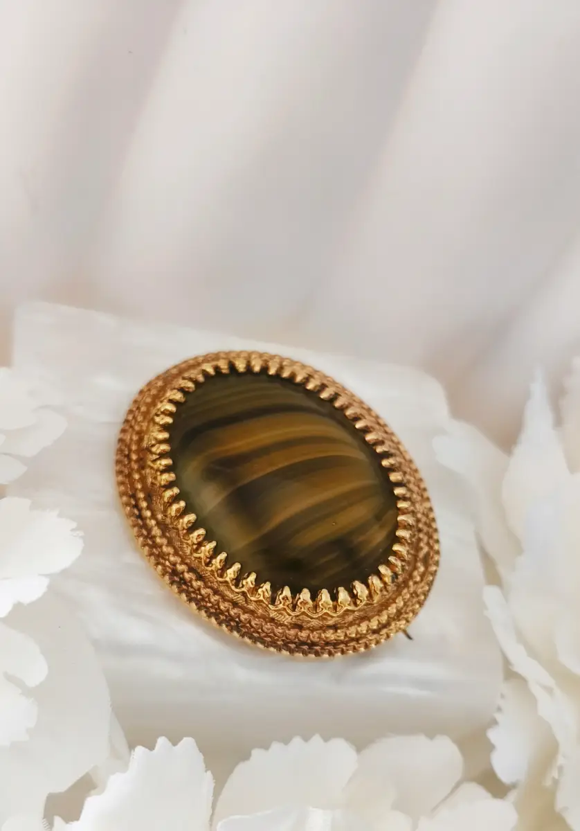 Vintage Sphinx oval gold tone brooch with green gem