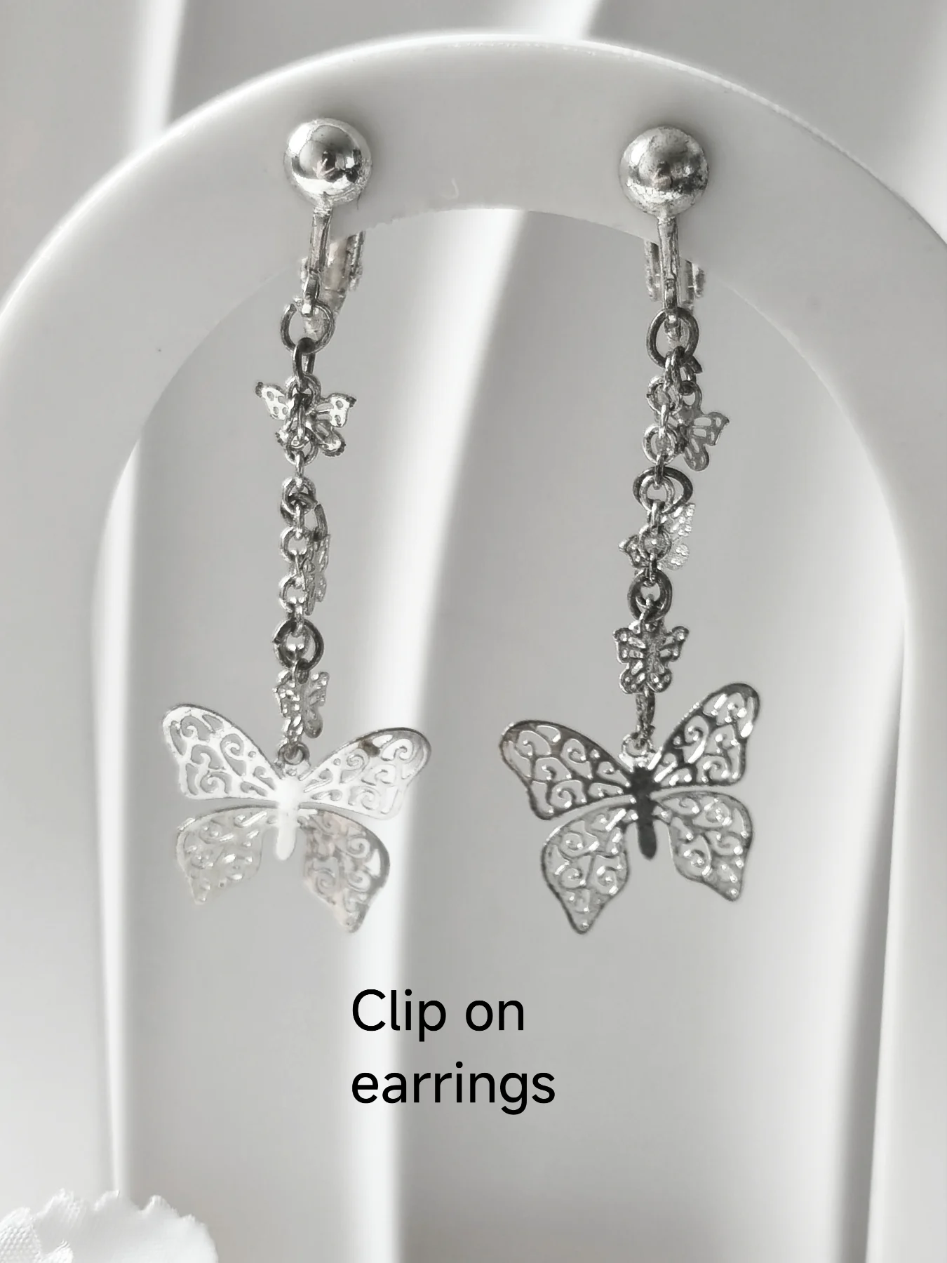 Silver tone clip on butterfly filigree drop earrings