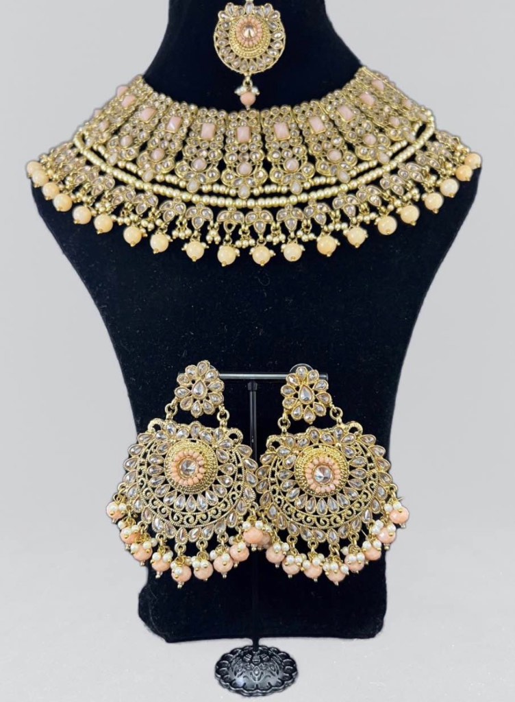 gold toned jewellery set featuring necklace earrings and tikka