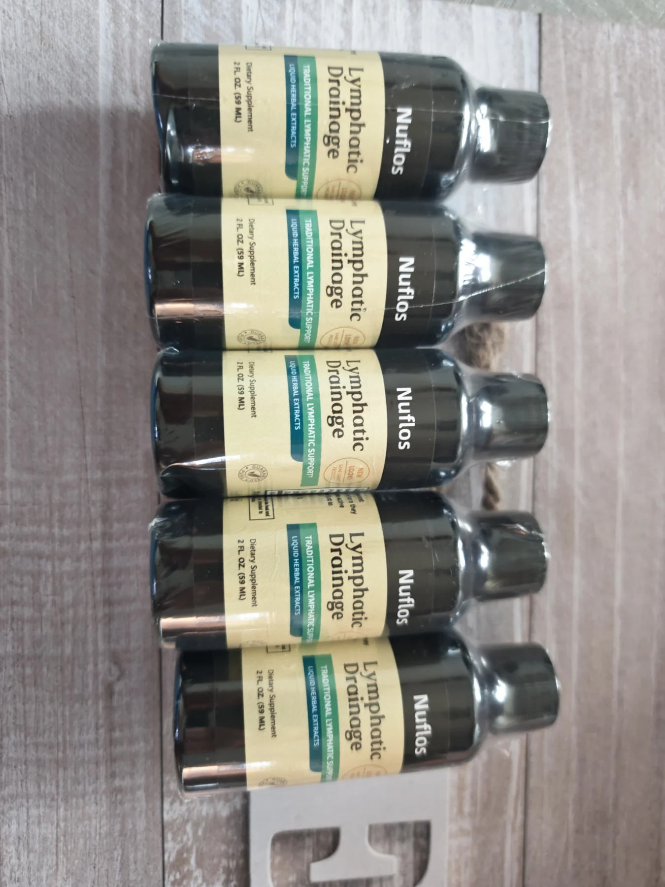 "Nuflos Lymphatic Drainage," a liquid herbal dietary supplement in a 2 fl. oz (59 mL) size.