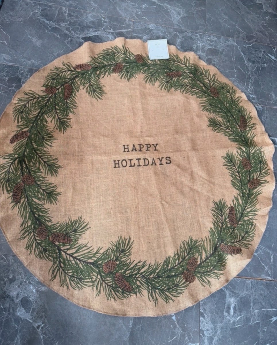 H&M Jute Christmas tree mat with a pine needle and pinecone print and "Happy Holidays" text