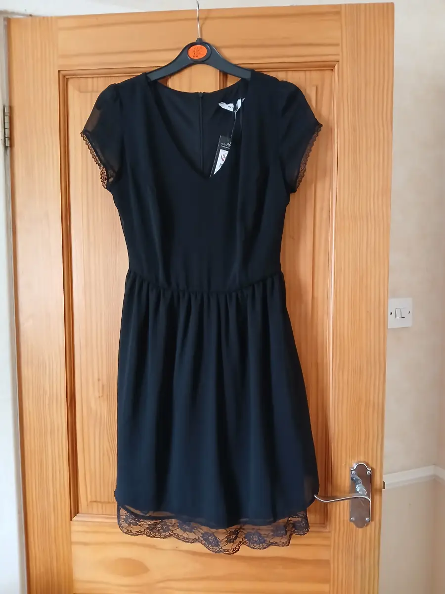 Black dress with lace edging on sleeves and hem