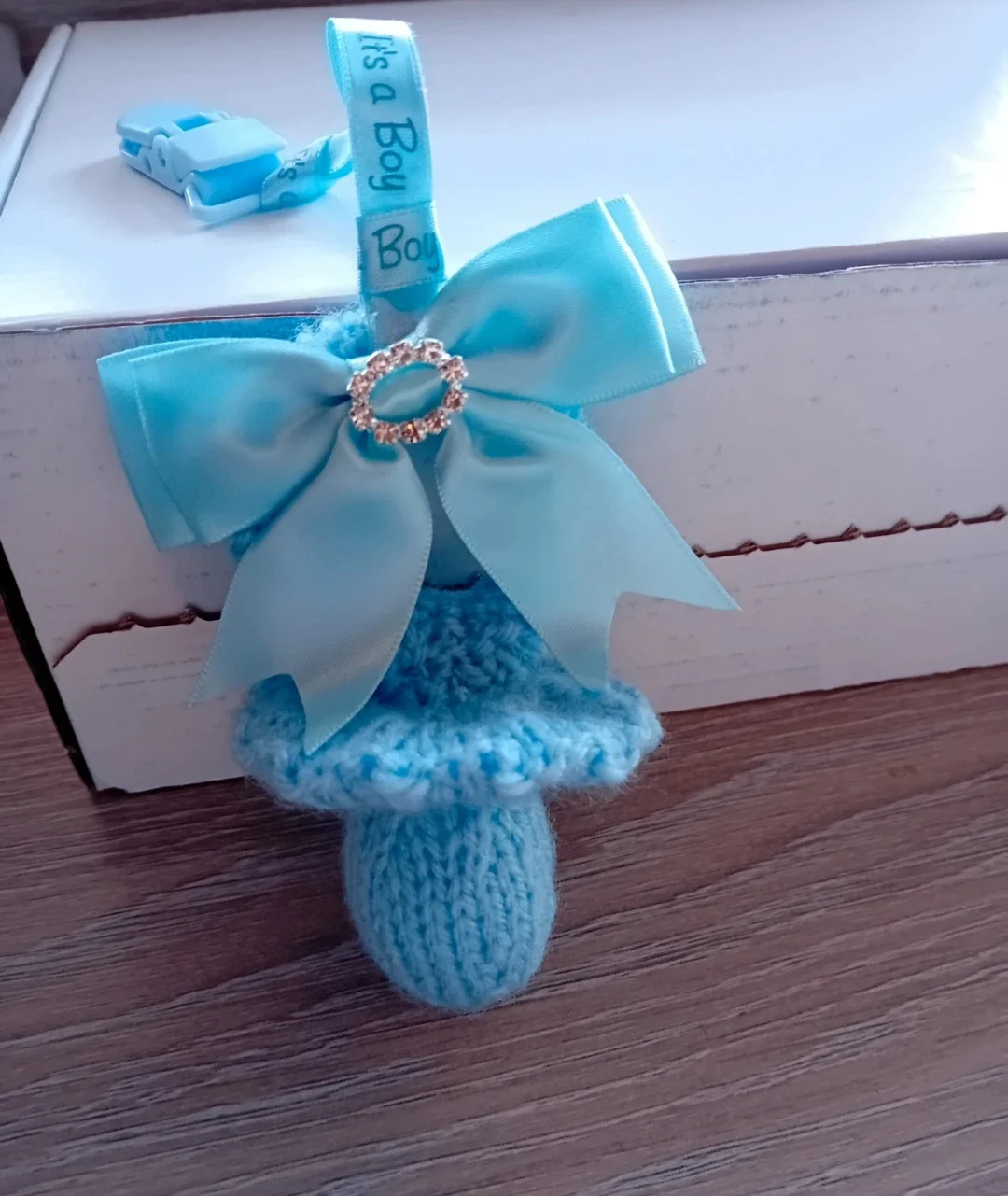 Baby boys blue knitted dummy pushchair clip