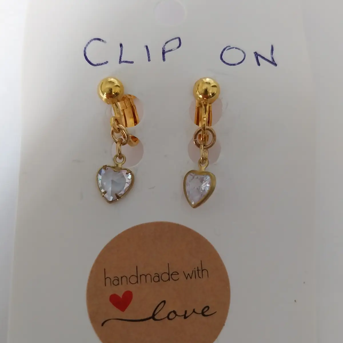 Clip on gold coloured earrings with heart pendants