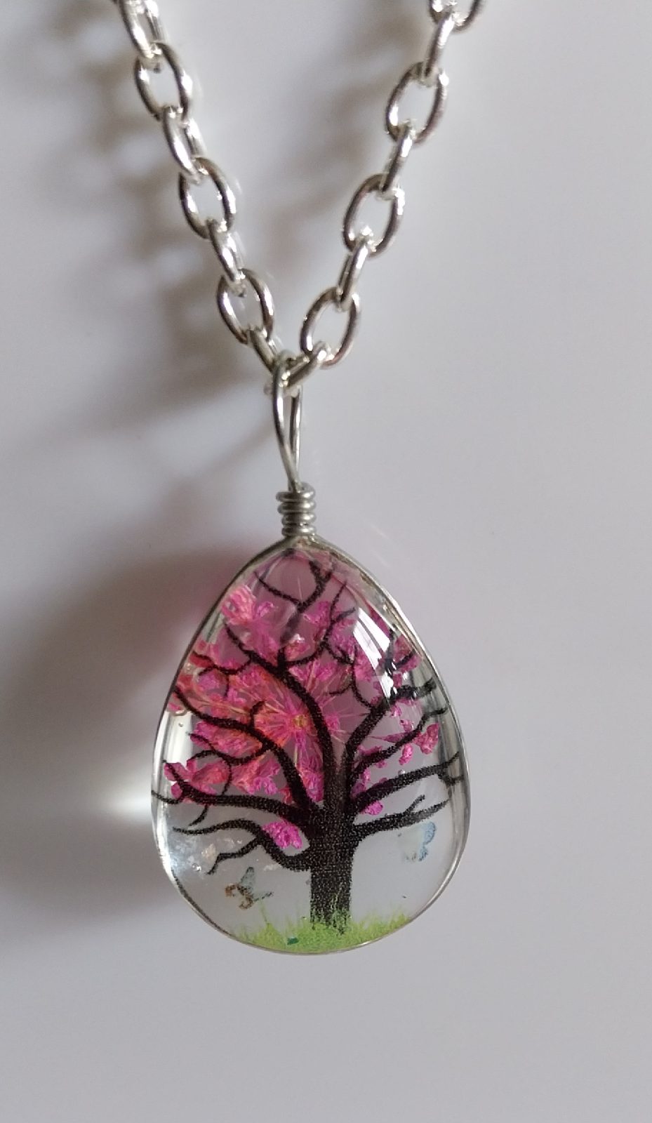 Pendant style silver coloured necklace with tree design