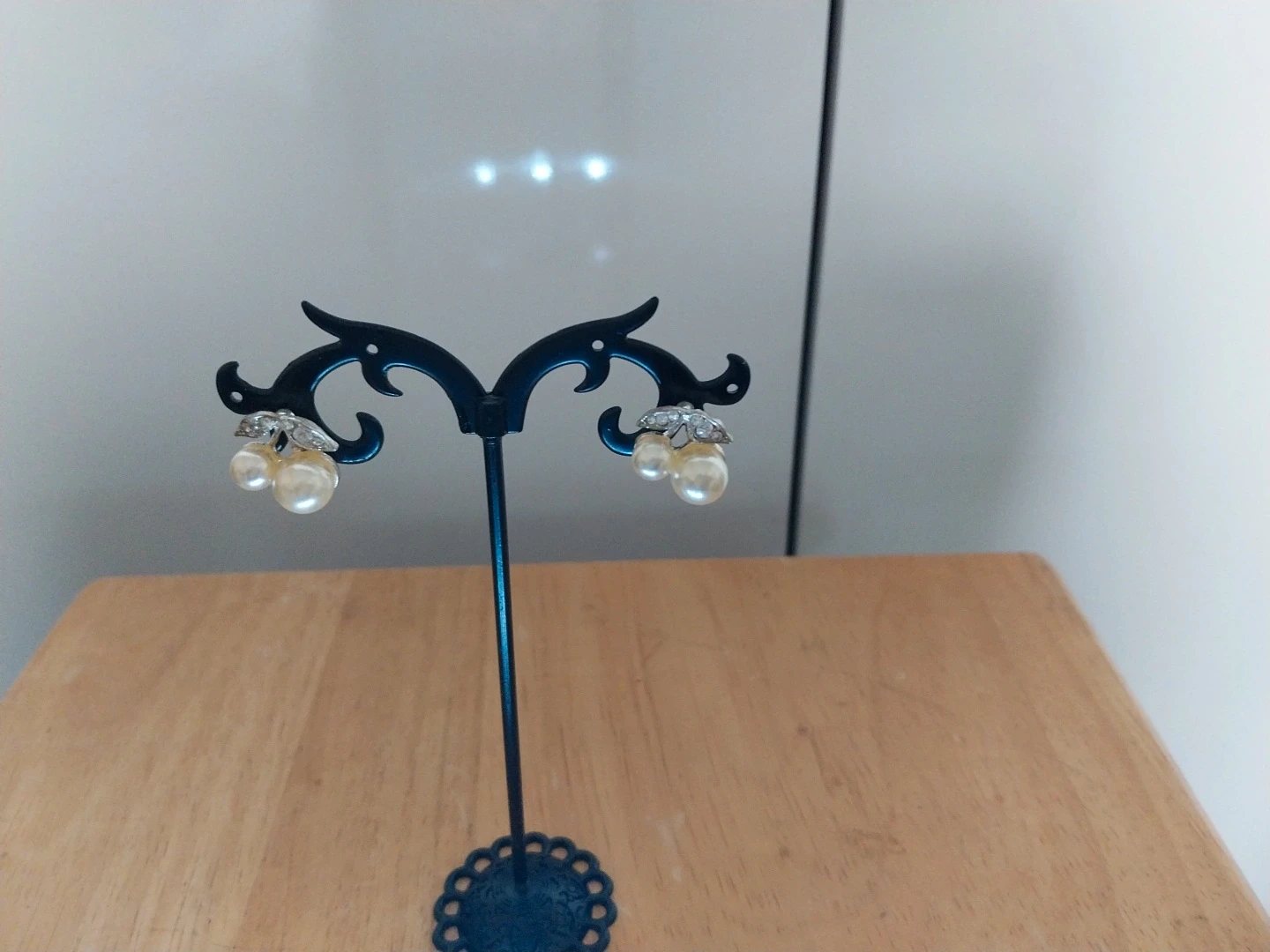 Silver coloured earrings with pearl beads & diamante leaves
