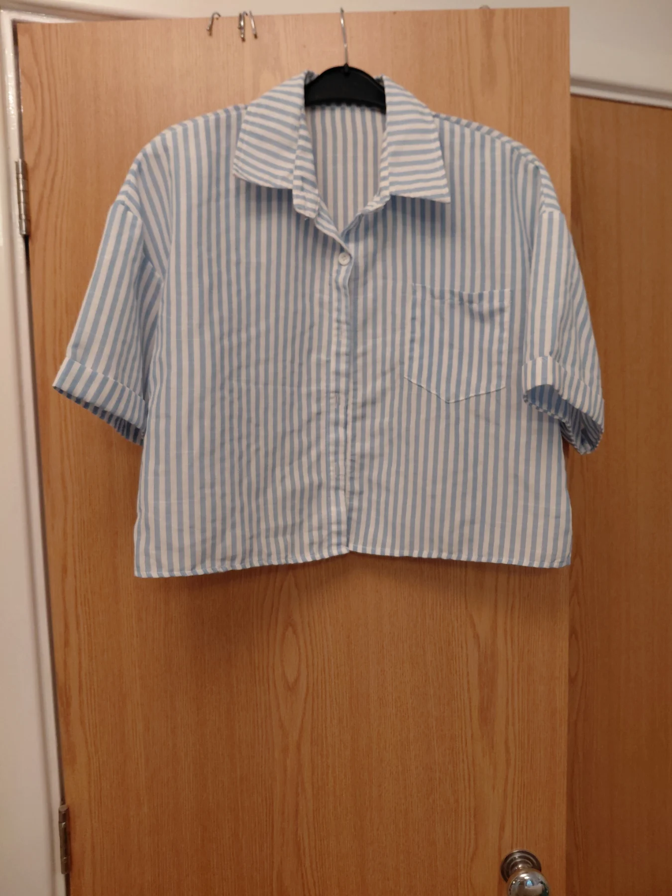 Short waisted shirt with short sleeves. Has a linen feel but polyester.