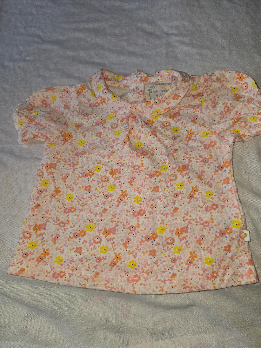 Leigh Tucker Girls top. Size 6-9 months. White with peach Colour pattern. New