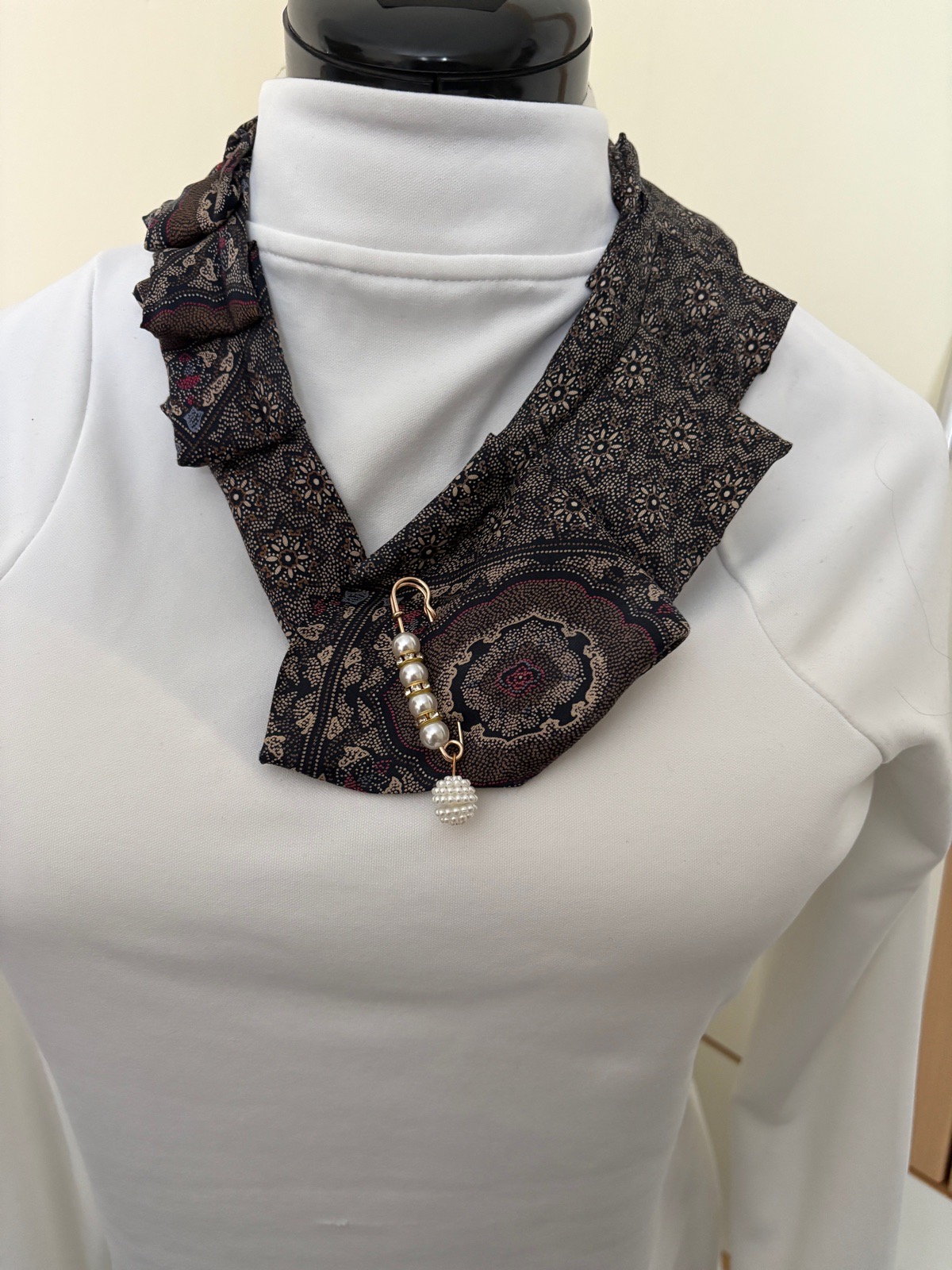 Necktie with brooch