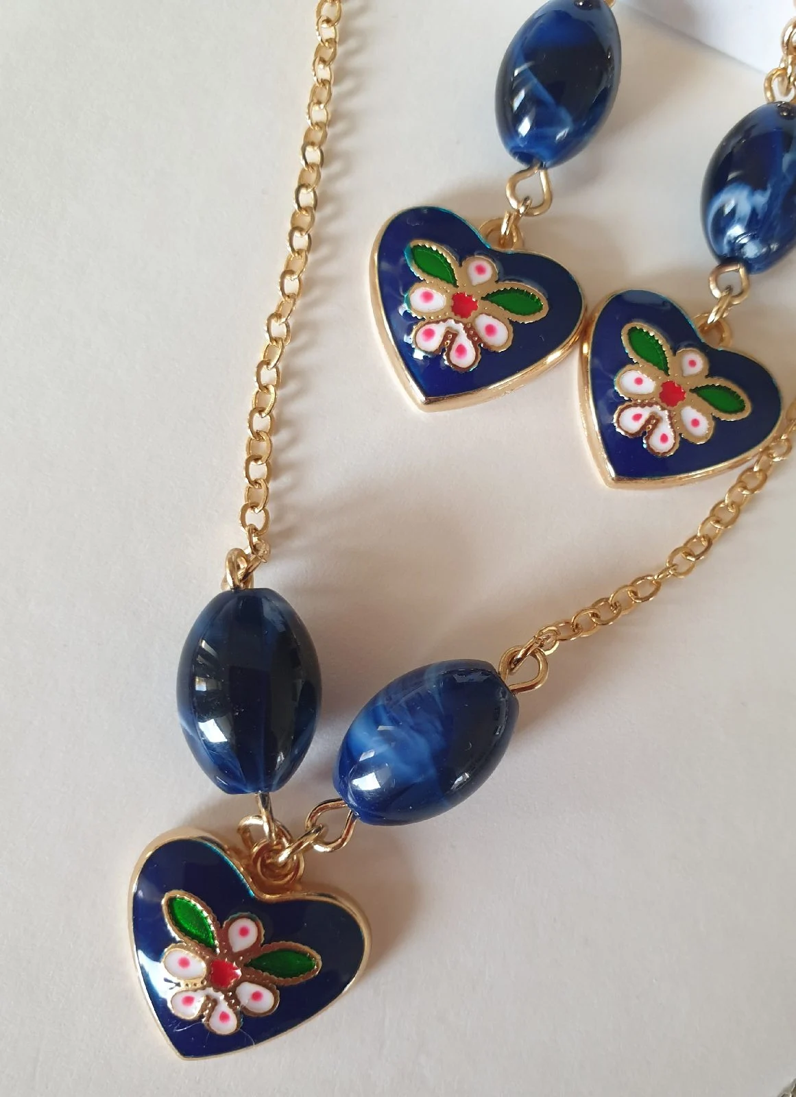 Blue heart necklace and earrings set features a floral design with gold accents