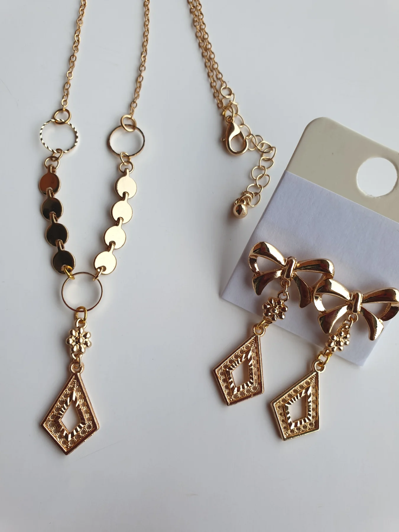 Gold-tone jewellery set with filigree style pendant and necklace, and bow earrings.