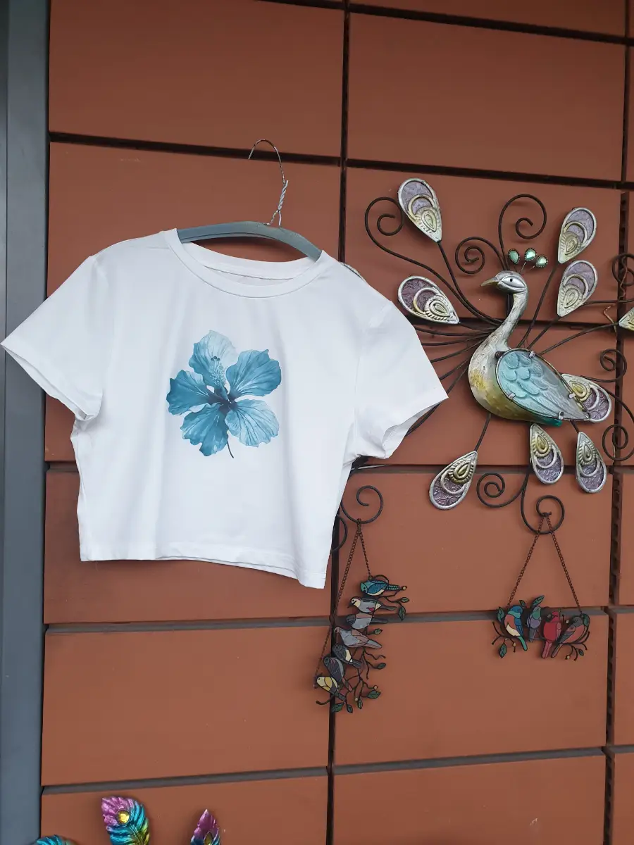 white crop top with blue hibiscus flower graphic, size L. Polyester & elastane blend. #