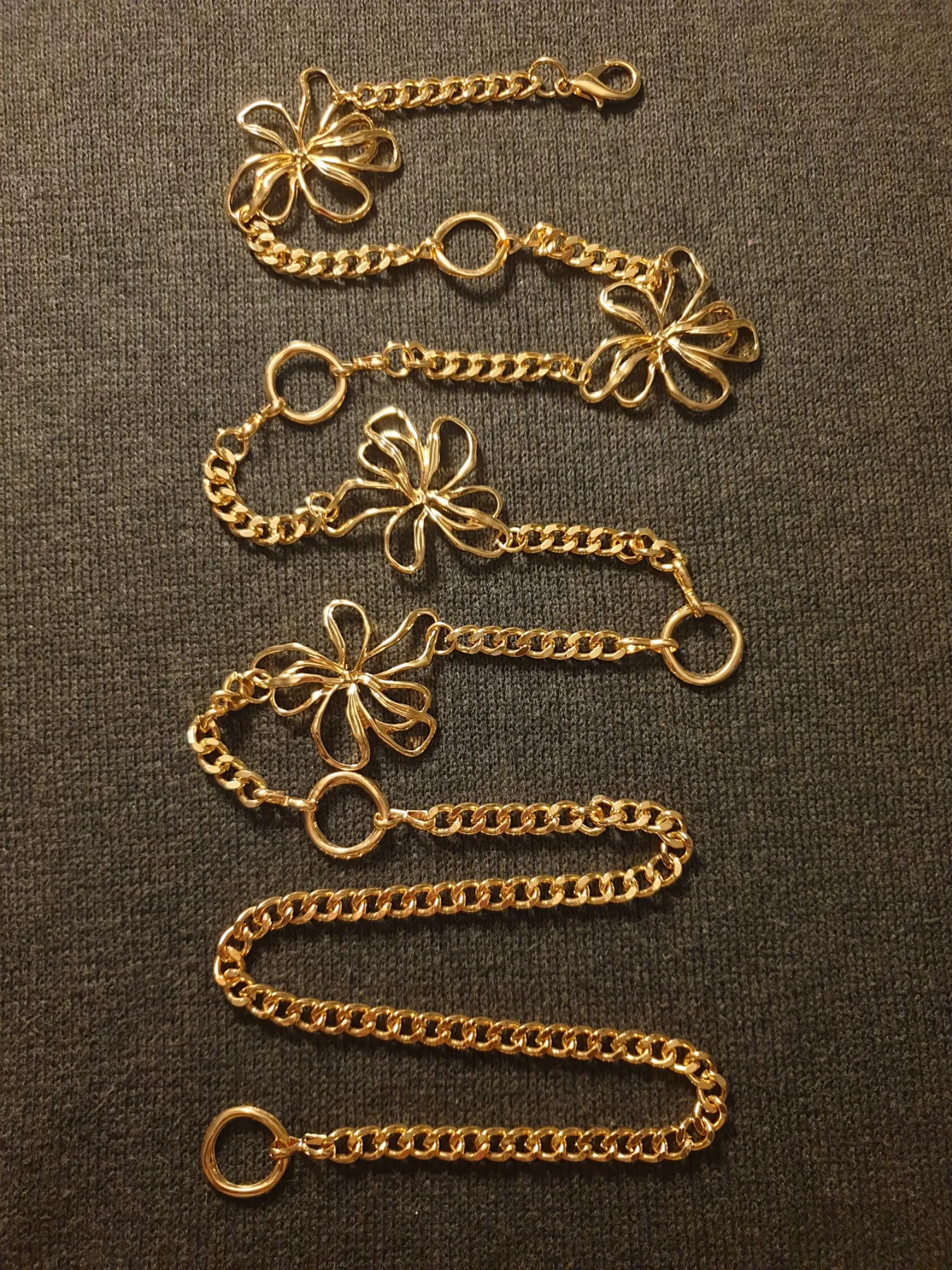 Gold-tone adjustable chain belt with flowers and circular rings. 117cm