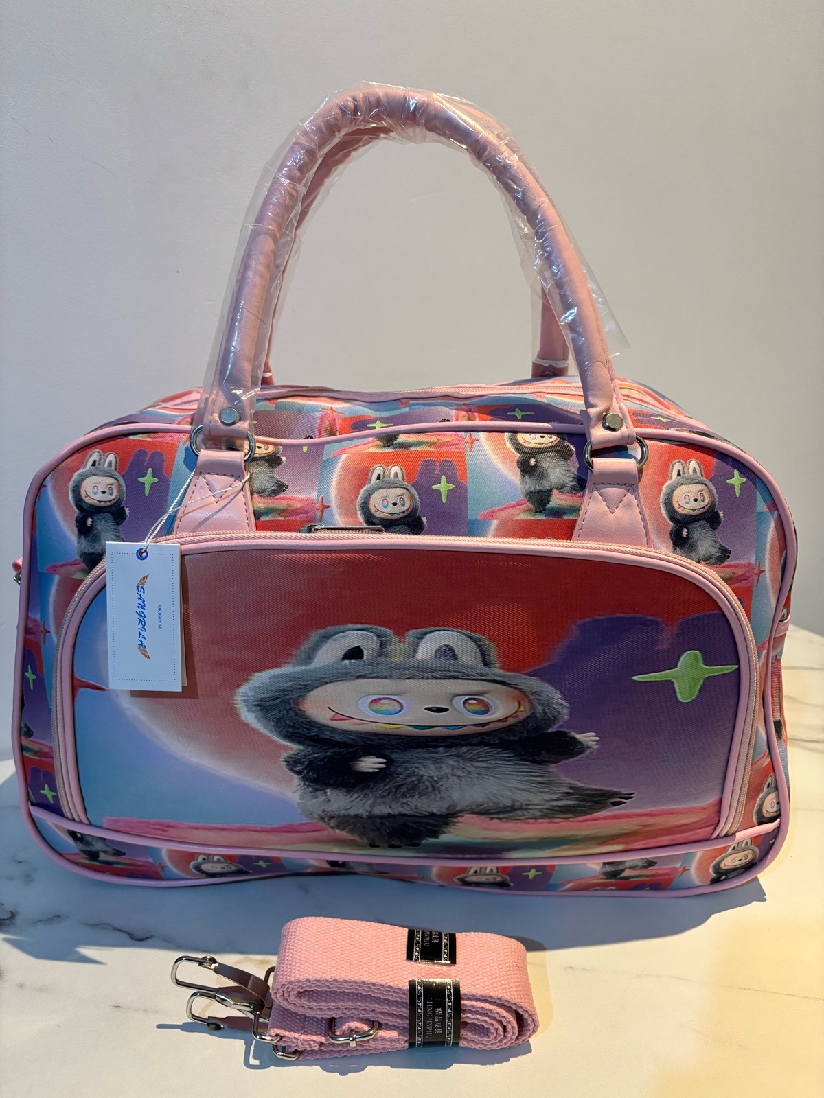 Pink character print travel bag with shoulder strap