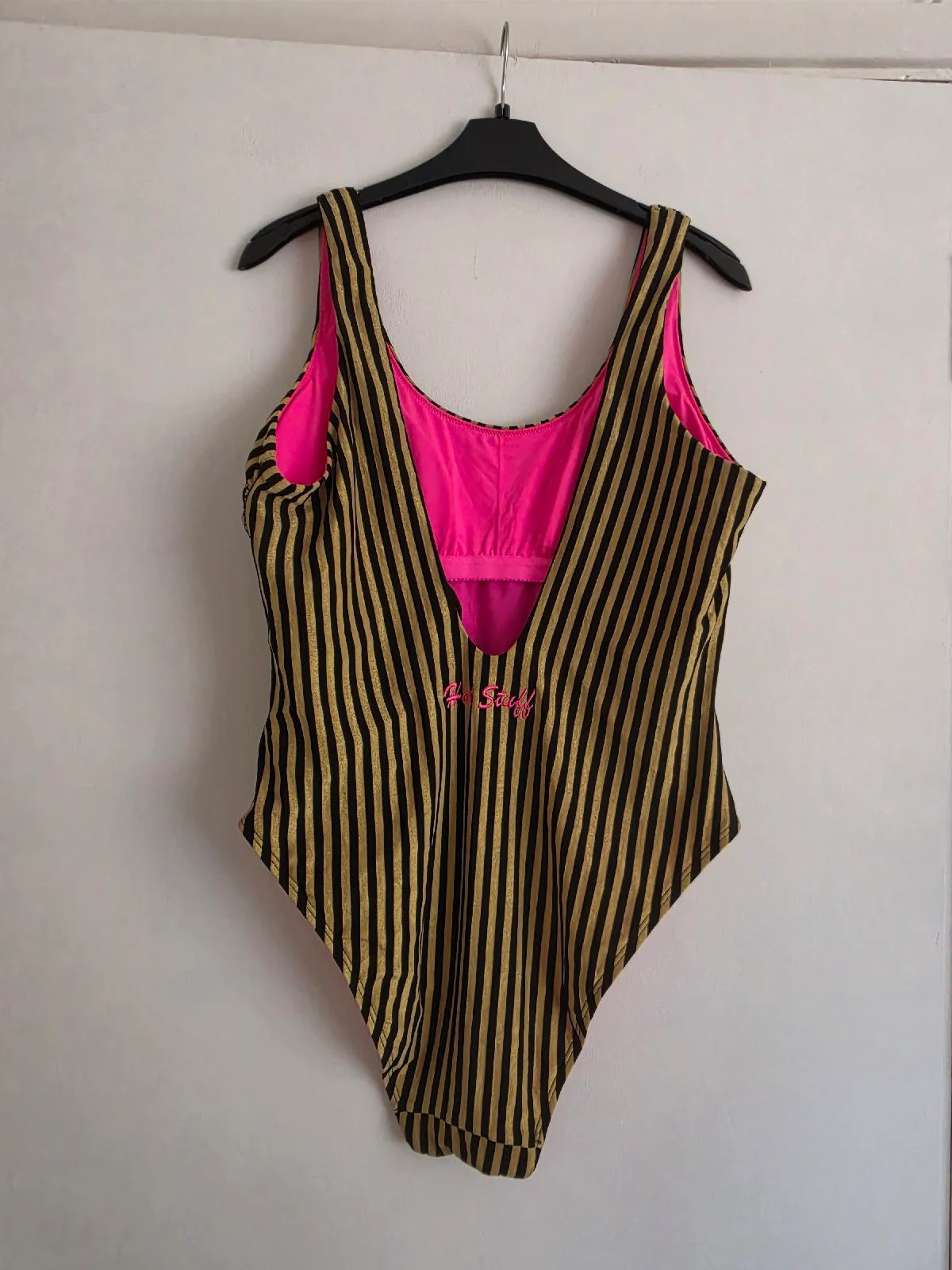 One-piece swimsuit with black and gold stripes.