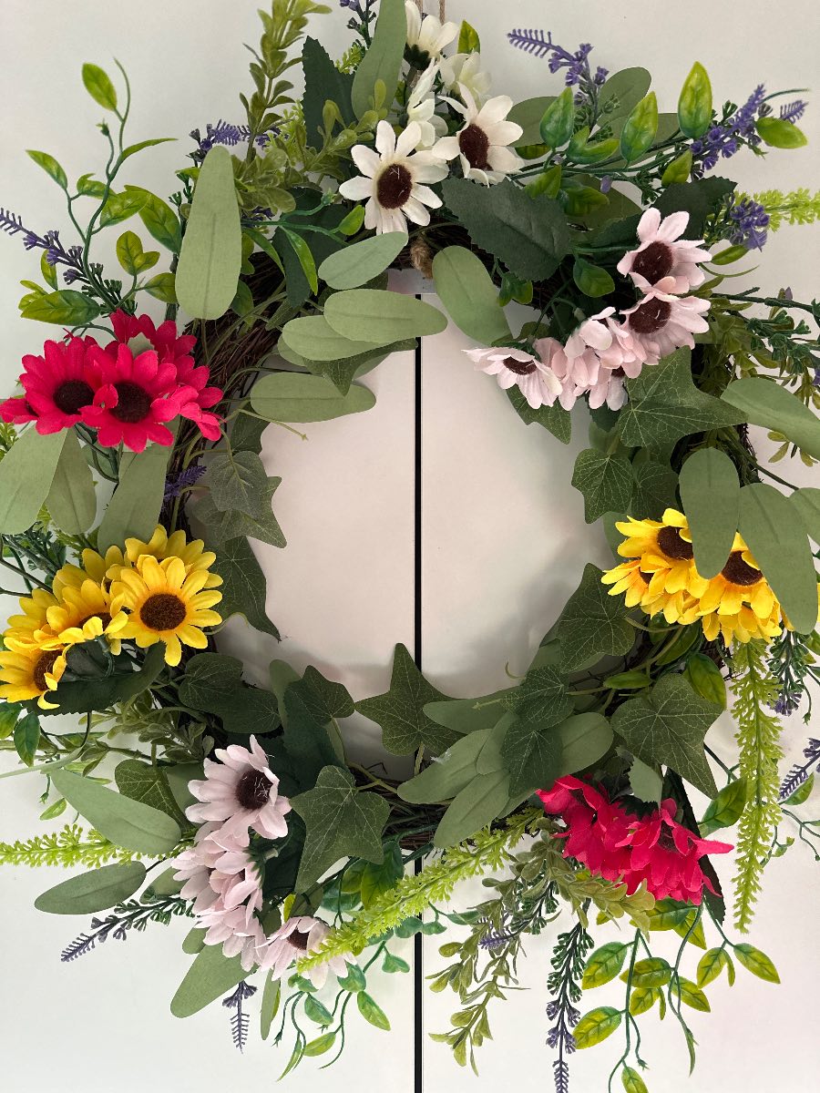 Faux floral door wreath multi coloured flowers and green foliage on a twig wreath