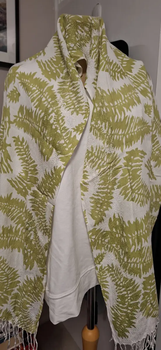 White scarf with green leaf pattern, tie rack