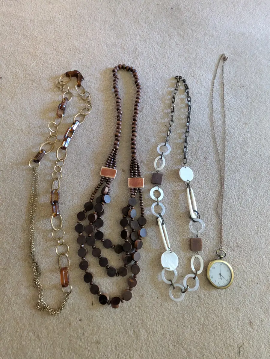 Selection of 4 long necklaces in shades of brown and gold, one with a watch.