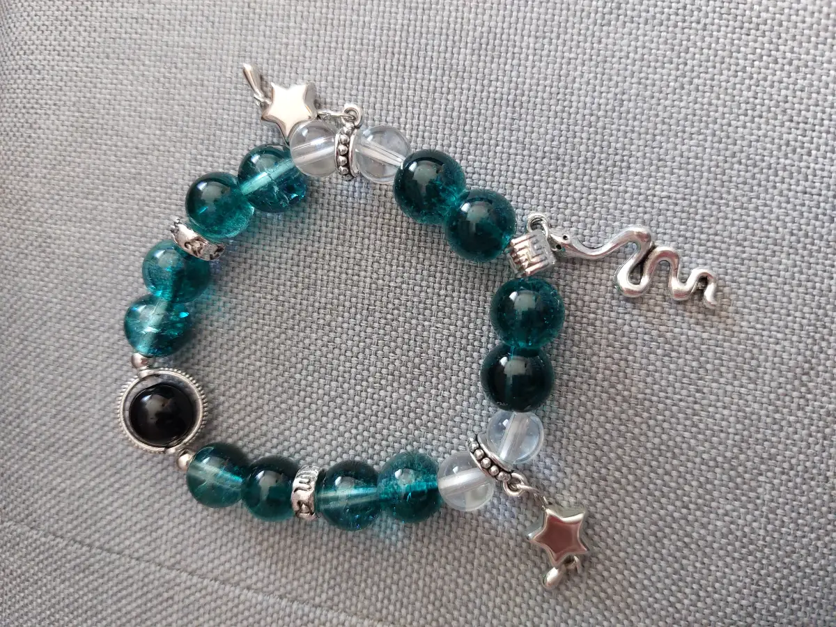 Teal beaded bracelet with silver colour charms