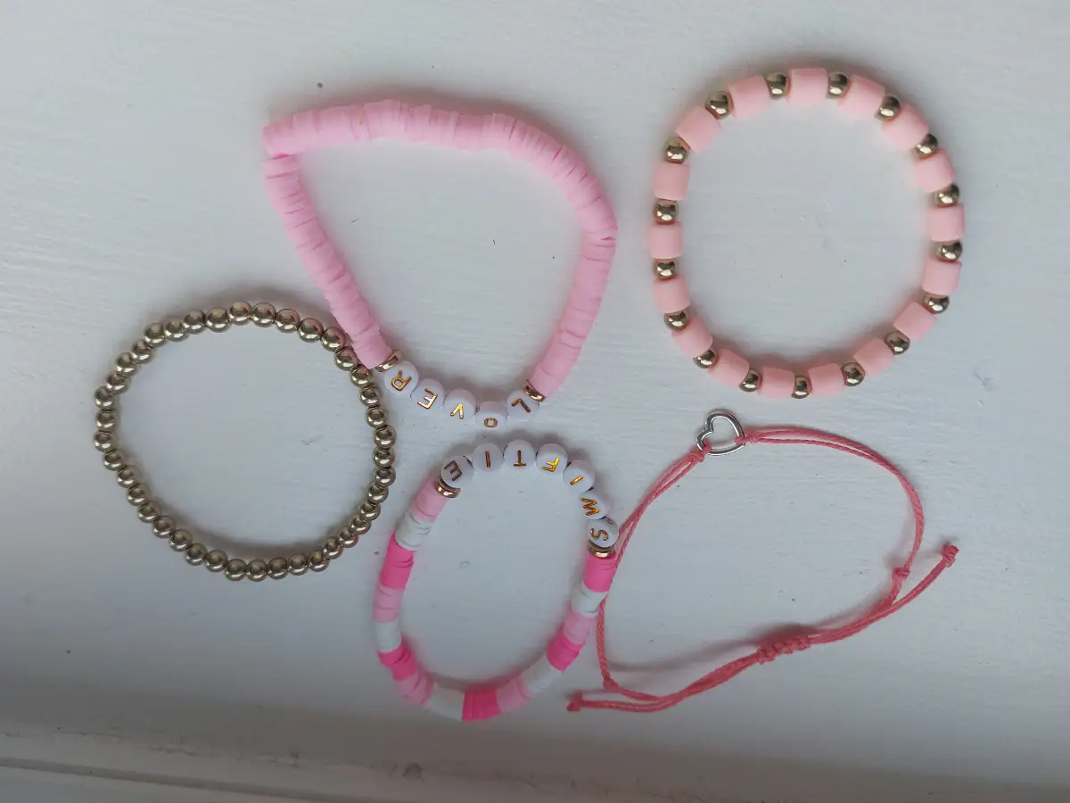 Five pink and gold friendship bracelets