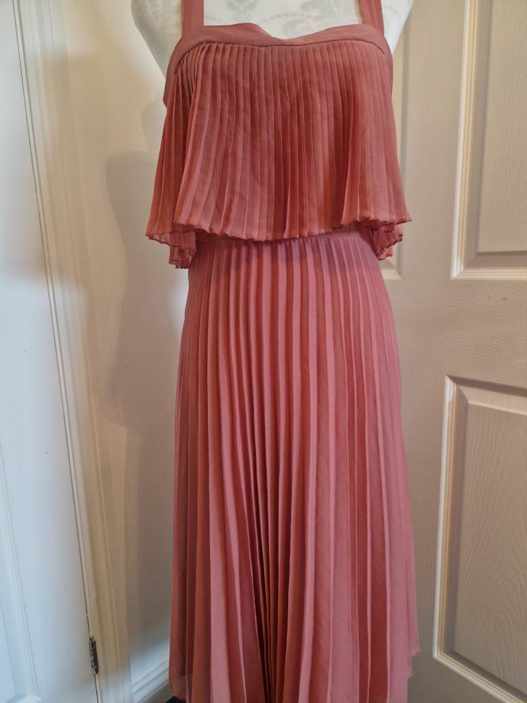 pleated maxi dress in a dusty rose pink hue featuring a layered bodice.