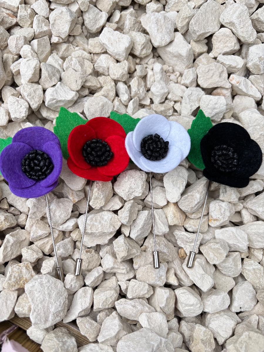 Set of four felt poppy lapel pins.