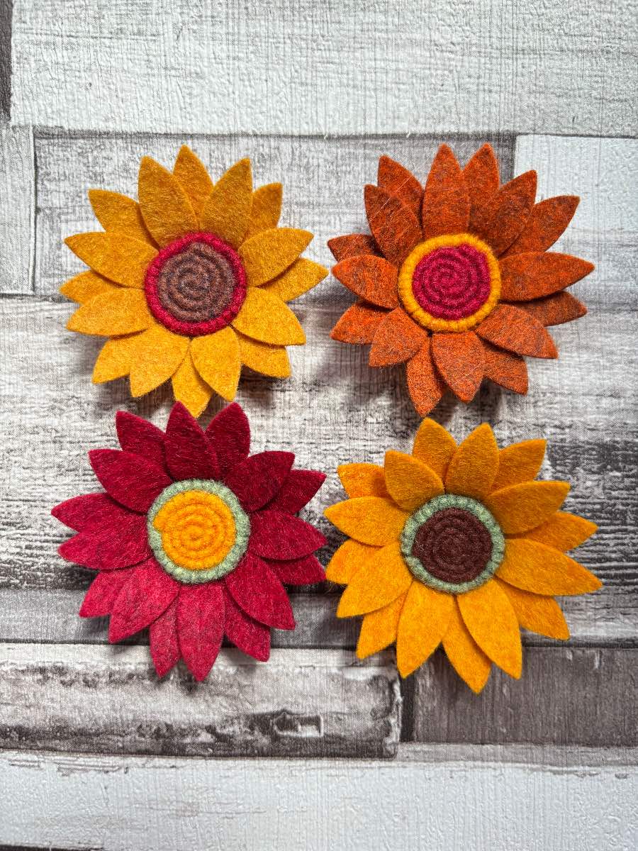 Four felt flowers in autumnal shades