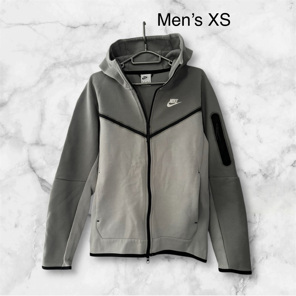 Nike Tech Fleece (Men’s) full Zip up Hoodie in light & dark Grey with a black trim. Size XS